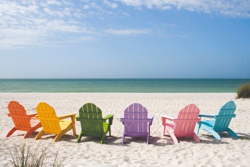 Seks stole i
  forskellige farver på en strand